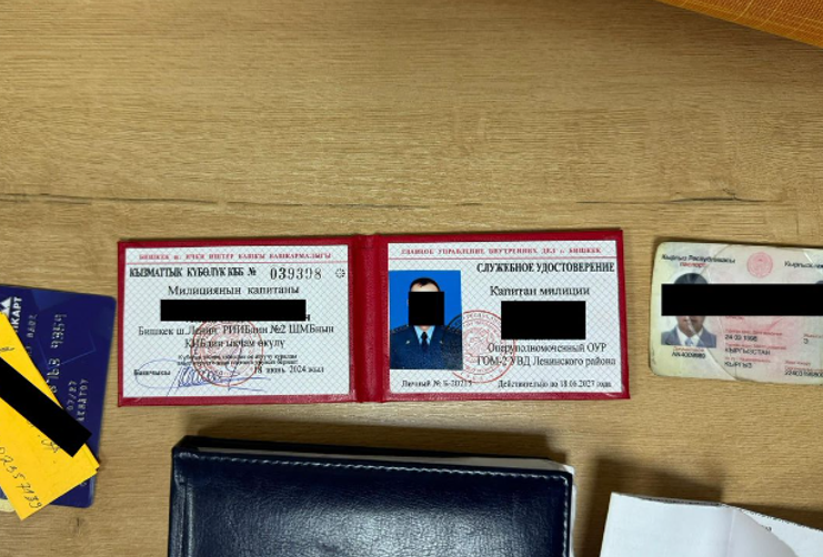 УКМК милициянын майору менен капитанын 100 миң сом пара алууга шектеп кармады